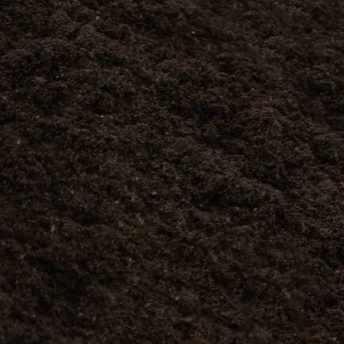 Eine Nahaufnahme von dunkler, lockerer Blumenerde, die für die Gartenpflege vorbereitet wurde. Sie zeigt eine gut bearbeitete Erde, die ideal für das Pflanzen von Blumen und Gräsern ist.