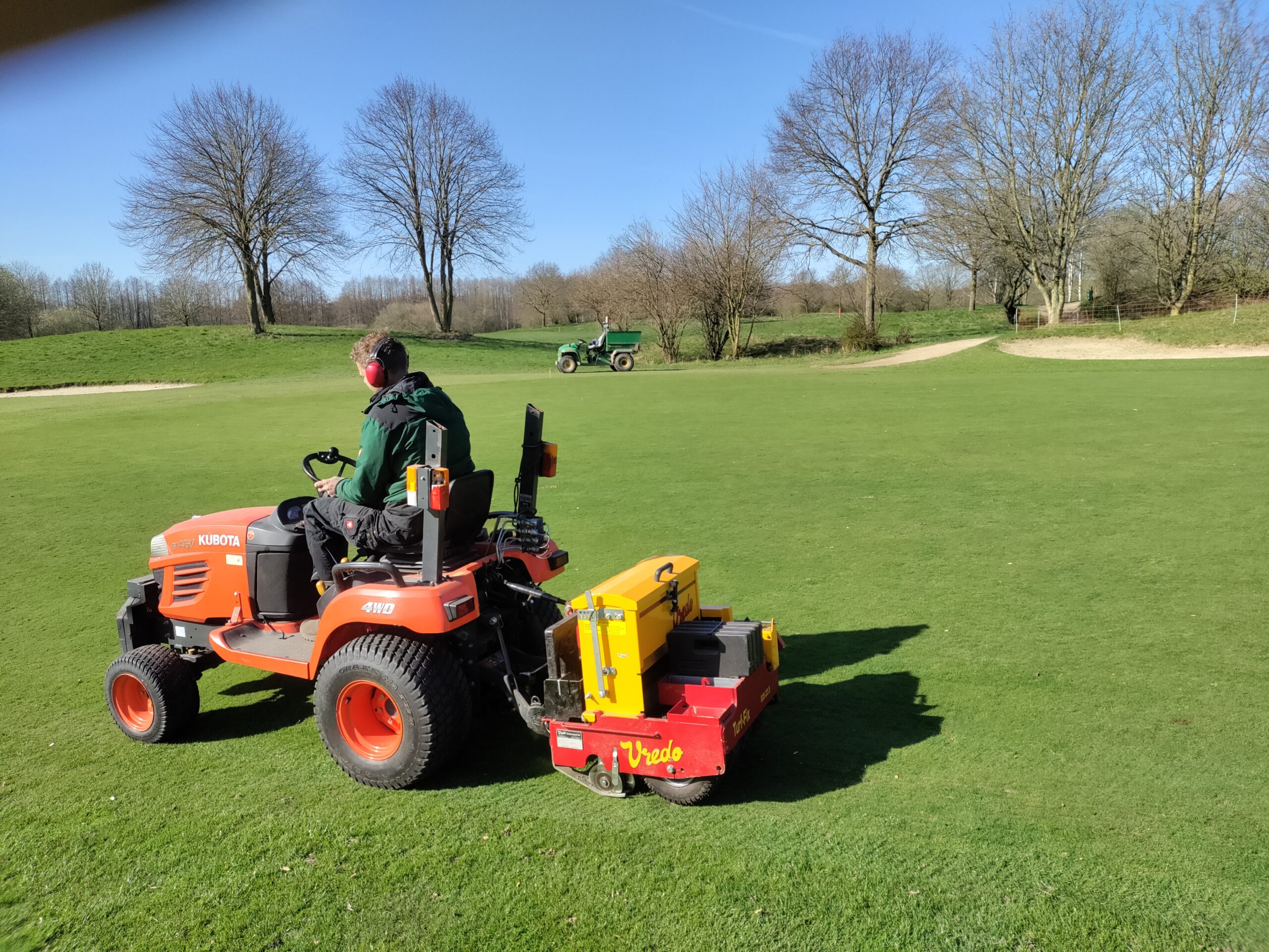 Rasenpflege mit einer Vredo-Nachsaatmaschine – durch gezielte Nachsaat wird der Rasaen regeneriert und widerstandsfähiger gegen Belastung.