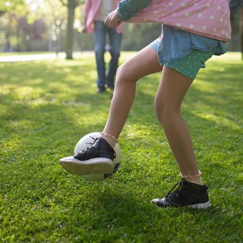 Kind spielt Fußball auf einem robusten Sportrasen. Der dichte und widerstandsfähige Rasen ist ideal für sportliche Aktivitäten und hohe Beanspruchung.
